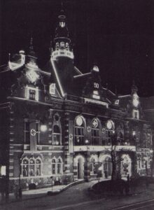 Slavnostně osvětlený Německý dům k narozeninám německého vůdce v roce 1939